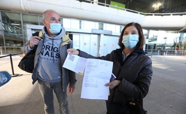 Imagen principal - Viajeros muestran a los medios sus resultados de PCR negativas. 