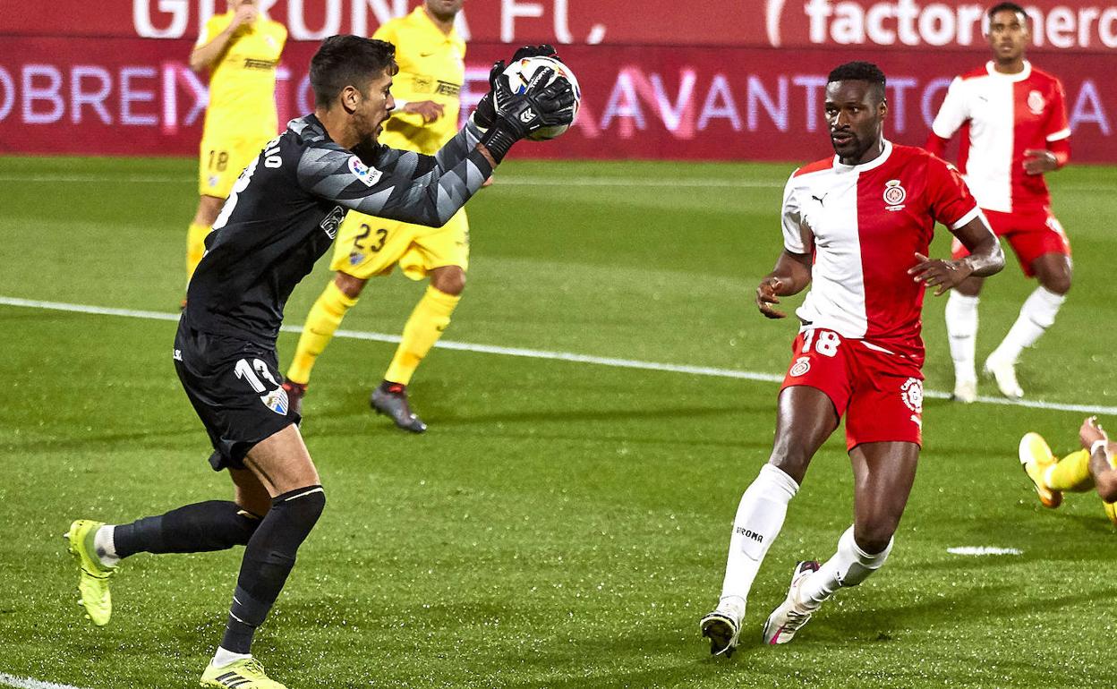 Dani Barrio, portero del Málaga, ataja un balón ante el máximo goleador del Girona, Sylla.