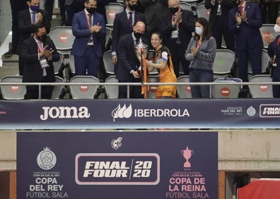 Imagen secundaria 1 - Las jugadoras de Burela se lanzan en plancha sobre la pista del Carpena en la celebración del título; sobre estas líneas. el presidente de la RFEF, Luis Rubiales, entrega el trofeo a Peque, capitana del Burela, y a la derecha, una disputa del partido entre Dany y Cristina Rivera.  