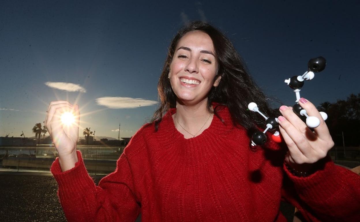 Ana María Amaya sonríe para la foto y sostiene un juego de moléculas, en el Muelle Uno. 