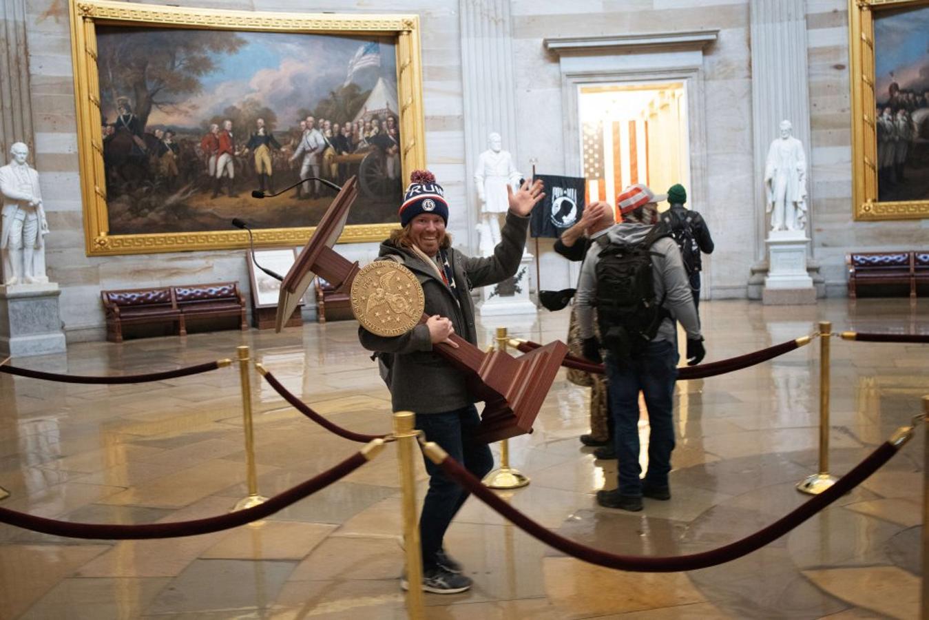 Un manifestante pro-Trump lleva el atril de la presidenta de la Cámara de Representantes de Estados Unidos