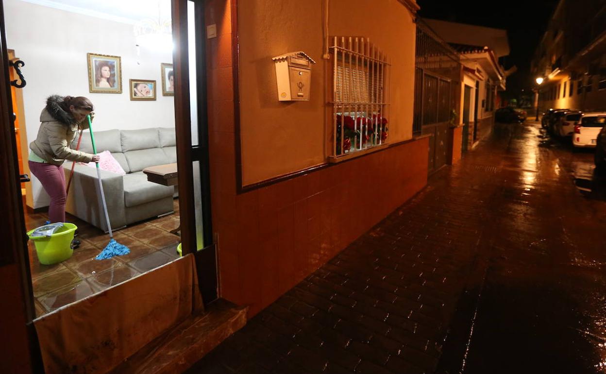 Una vecina limpia los restos del temporal en su vivienda. 