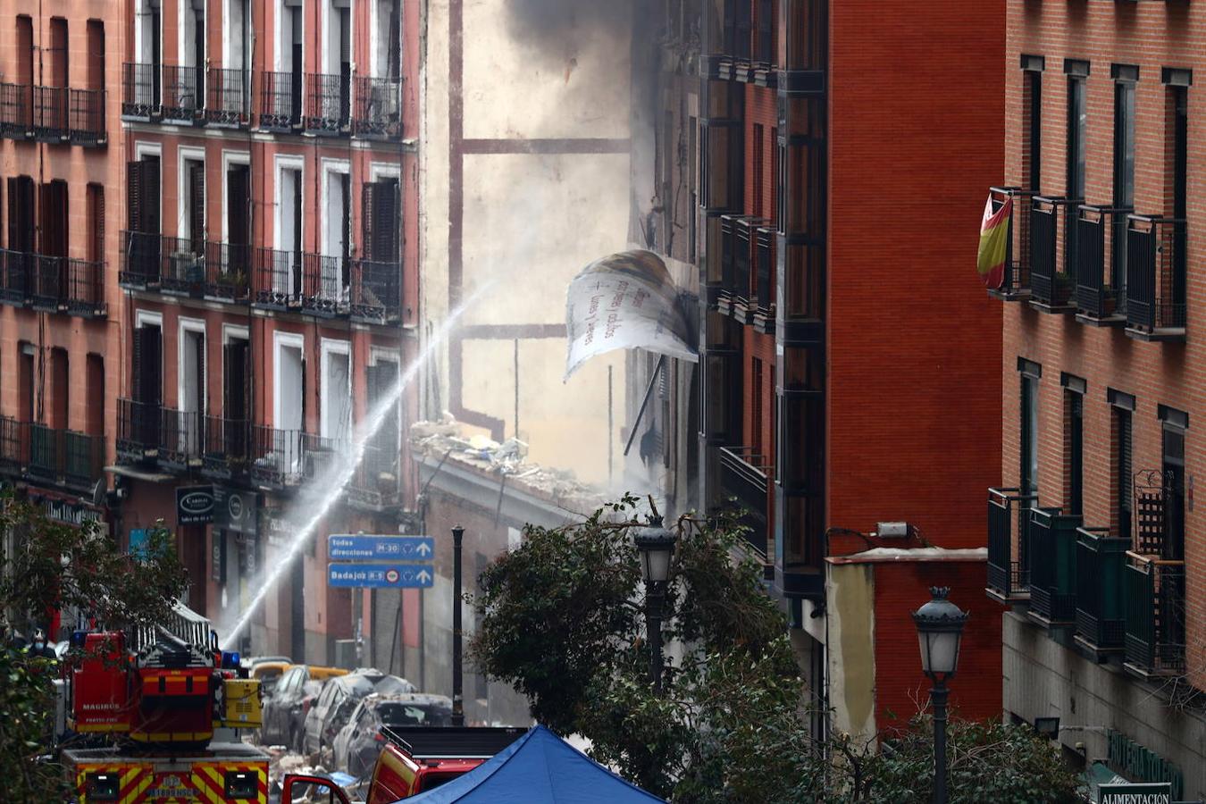 Los bomberos rocían agua en un edificio perteneciente a la Iglesia Católica, luego de una explosión mortal, en el centro de Madrid.