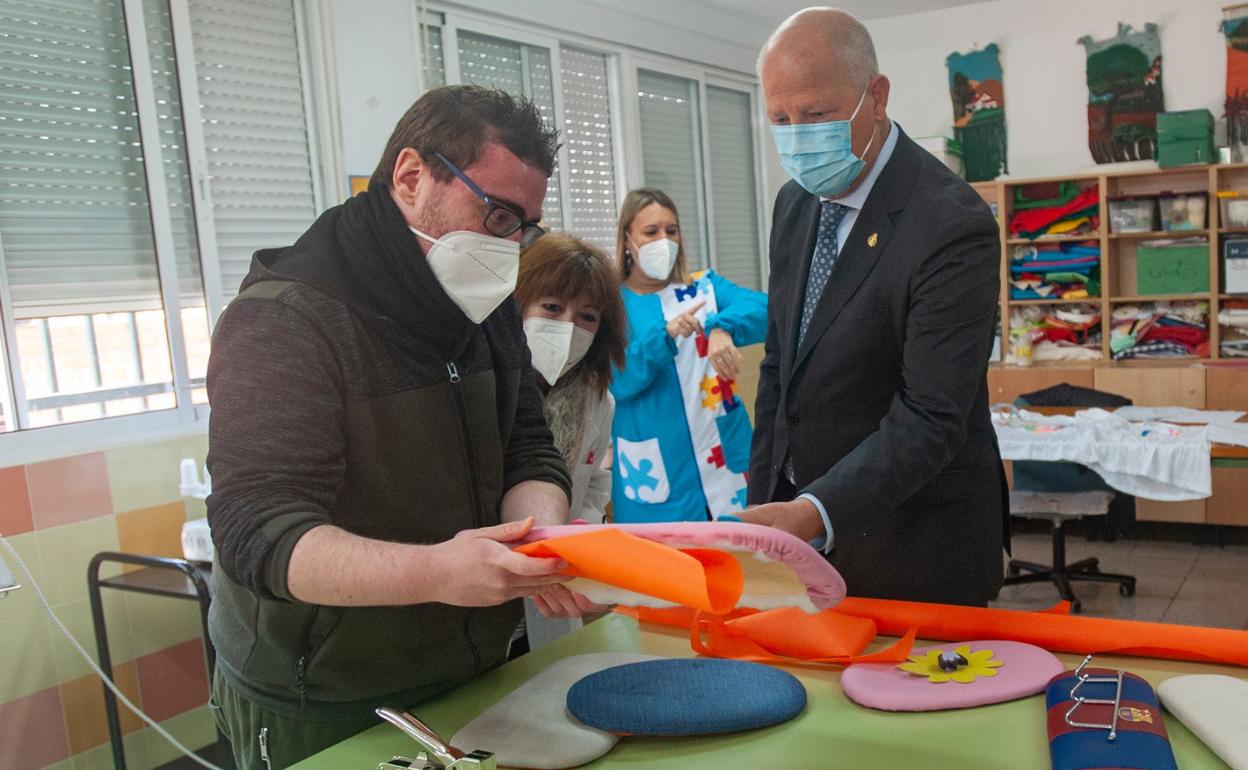 Francisco muestra al consejero sus trabajos de tapicería, que realizan en uno de los talleres del Centro Específico de Educación Especial Santa Rosa de Lima. 