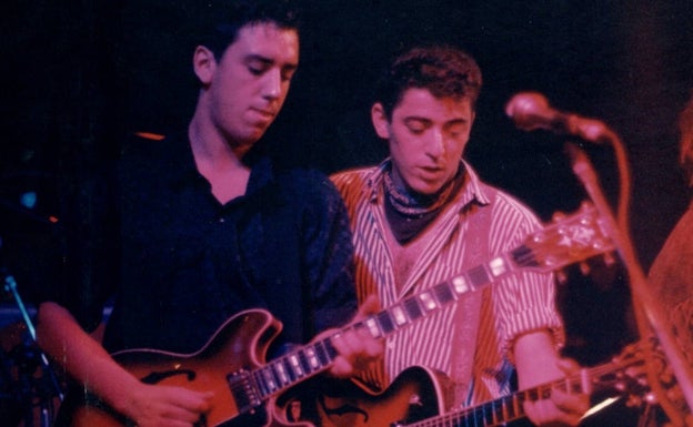 Imagen principal - Rafa Salas y Adolfo Flores, durante un concierto. Debajo, portada del disco inédito hasta ahora de Los Caimanes y la carátula del máster manuscrita por los propios músicos.