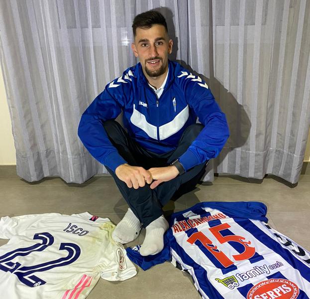 Alejando Camacho posa entre su camiseta en el Alcoyano y la de Isco en el Madrid.