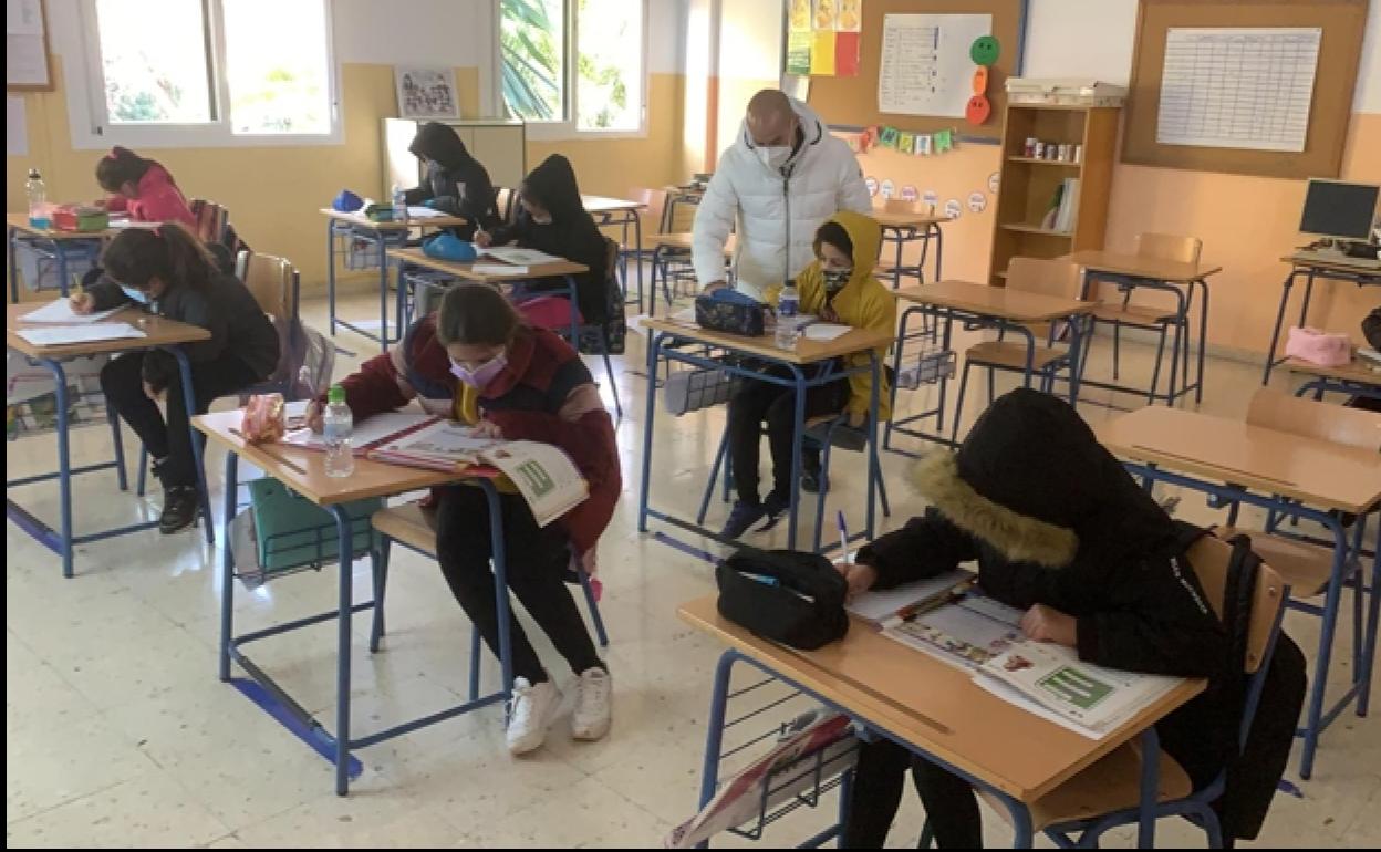 Una clase del colegio Manuel Altolaguirre de Málaga capital, con alumnos y profesor con abrigos.