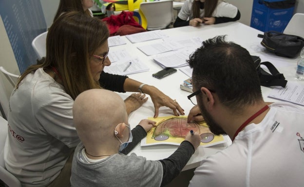 Voluntarios de la Casa Ronald Mcdonald jugando con un pequeño, en una foto de archivo.