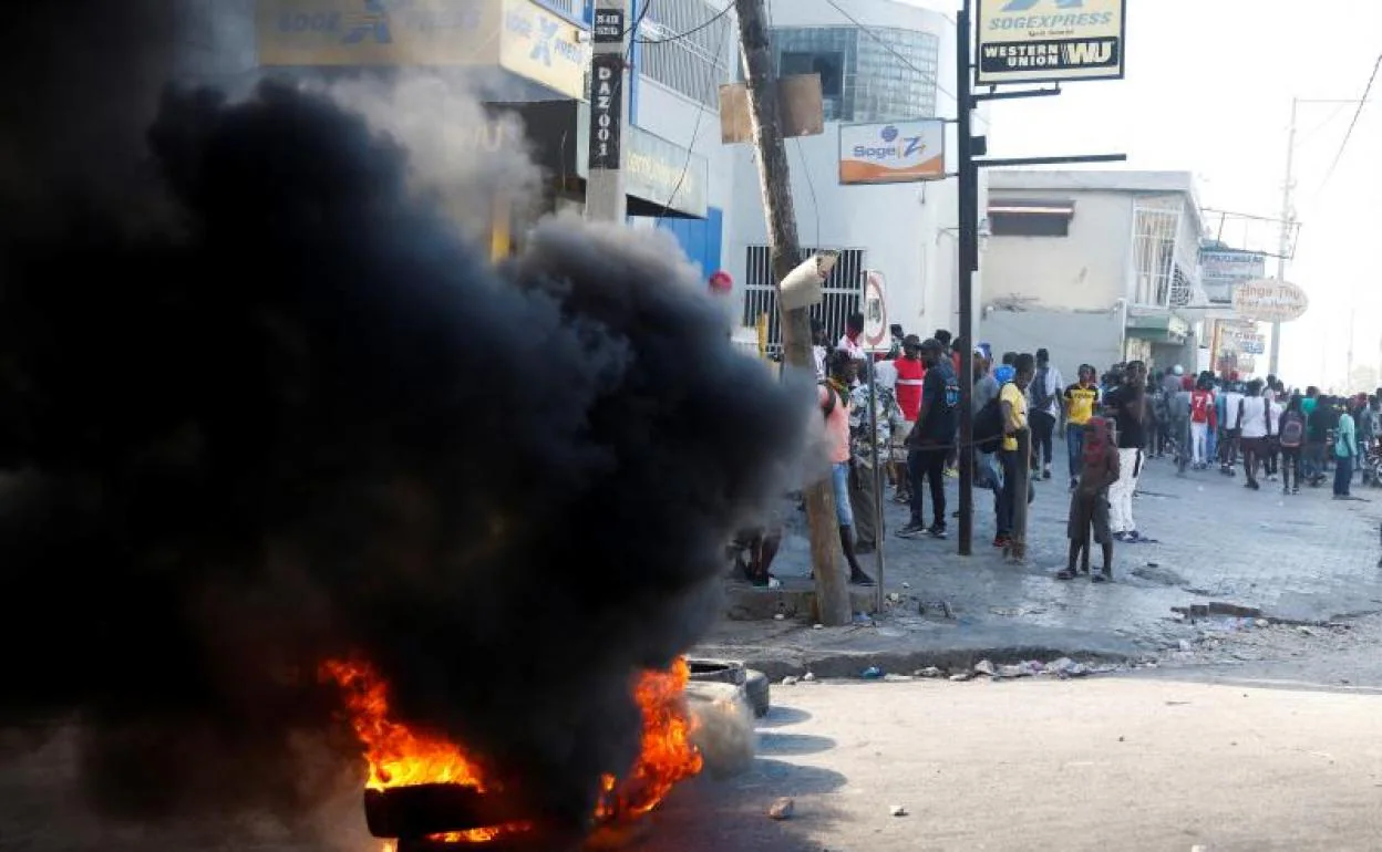 Un grupo de personas cerca de una barricada en las calles de Puerto Príncipe, en las protestas contra el presidente Moise.