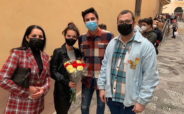 Una joven aguarda la cola para entregar un ramo de flores al Cristo de Medinaceli. 