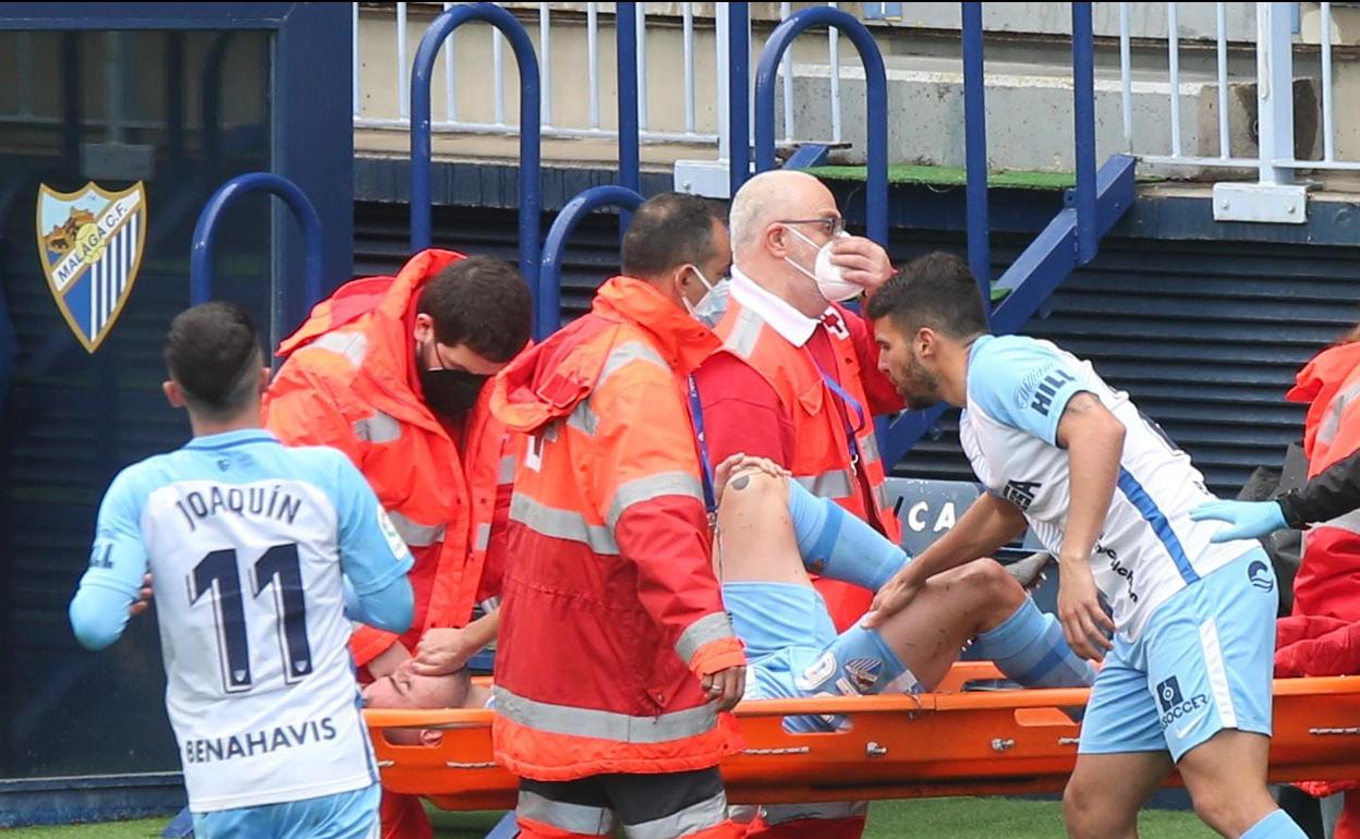 Momento en el que jugador del Málaga, Ismael Casas, es retirado del campo en camilla.