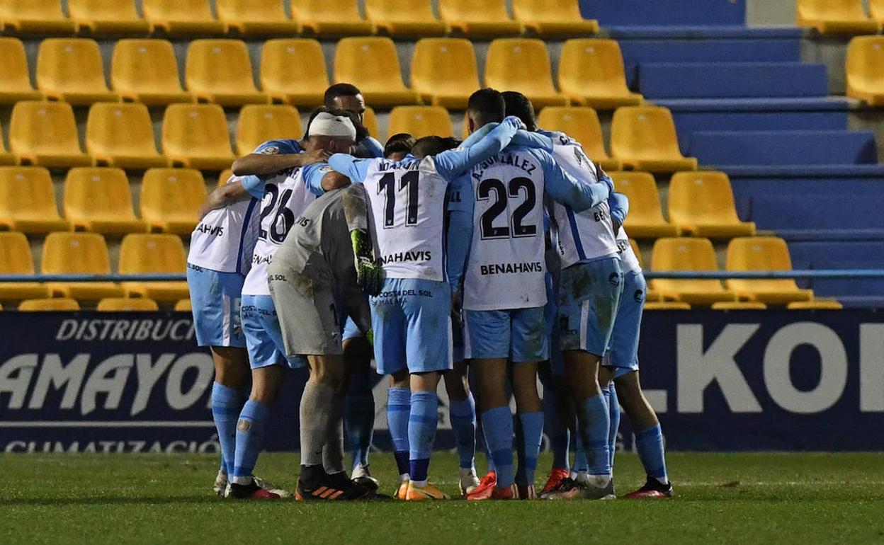 Jugadores del Málaga forman un círculo en el estadio de Santo Domingo en la que fue su última victoria a domicilio frente al Alcorcón en enero.