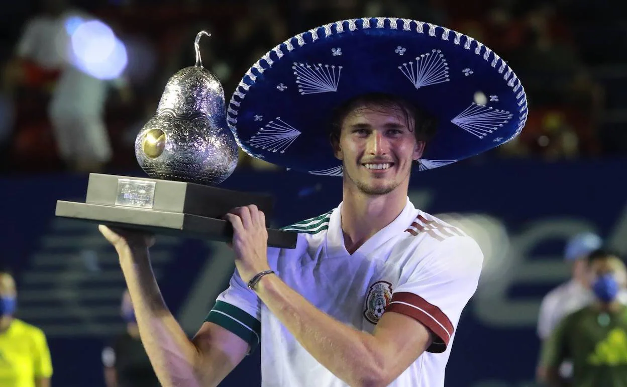 Alexander Zverev, con el trofeo de vencedor en el ATP 500 de Acapulco esta temporada y posando con la camiseta de la selección mexicana de fútbol. 
