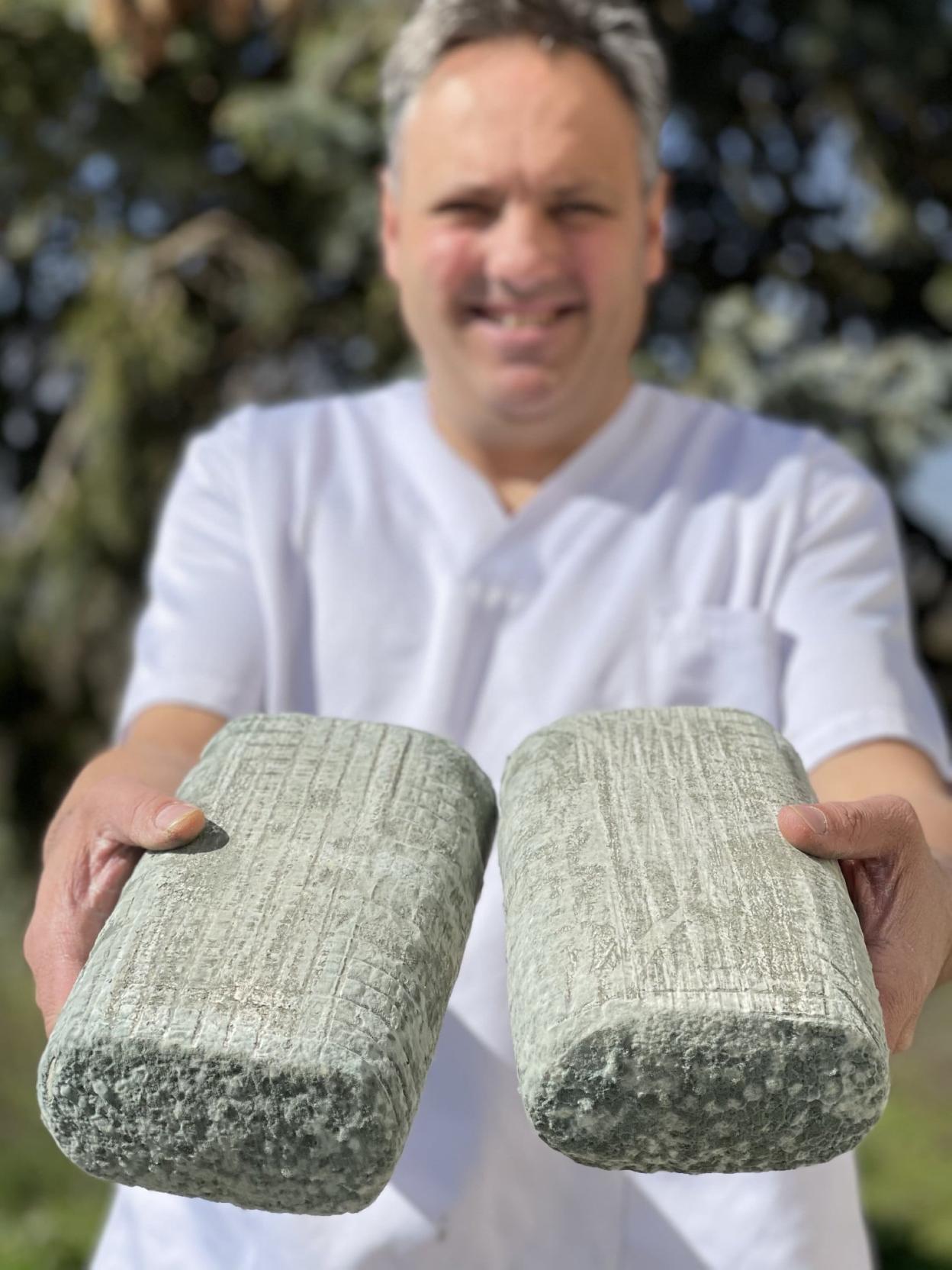 El quesero Fran muestra feliz dos piezas de su pata de mulo. R. C.