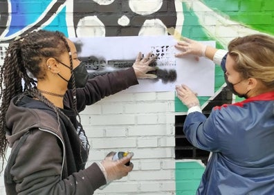 Imagen secundaria 1 - Los participantes en el proyecto, en la foto superior. Debajo, momentos de la intervención artística en los muros y fachadas de los patios. 