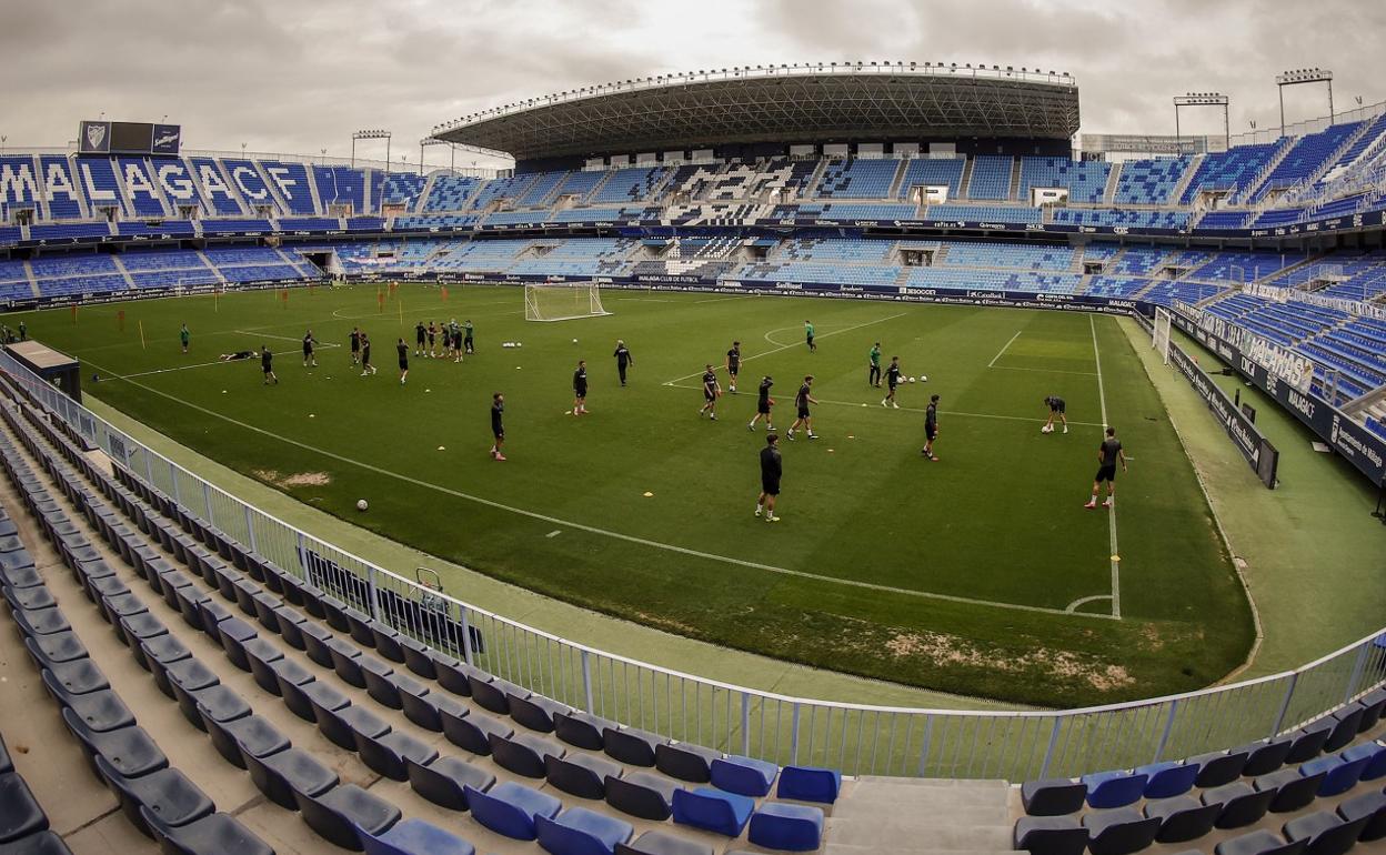 Jugadores del Málaga durante un entrenamiento reciente sobre el césped del estadio de La Rosaleda.
