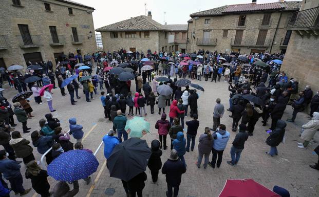 Imagen principal - Familia y vecinos de David Beriain, este miércoles, en la concentración en Artajona. 