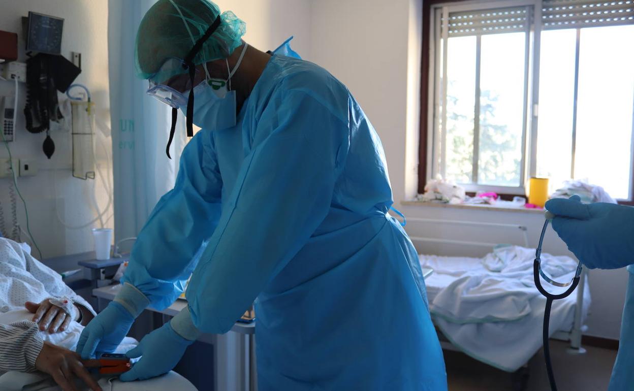 Un sanitario atiende a un paciente. 