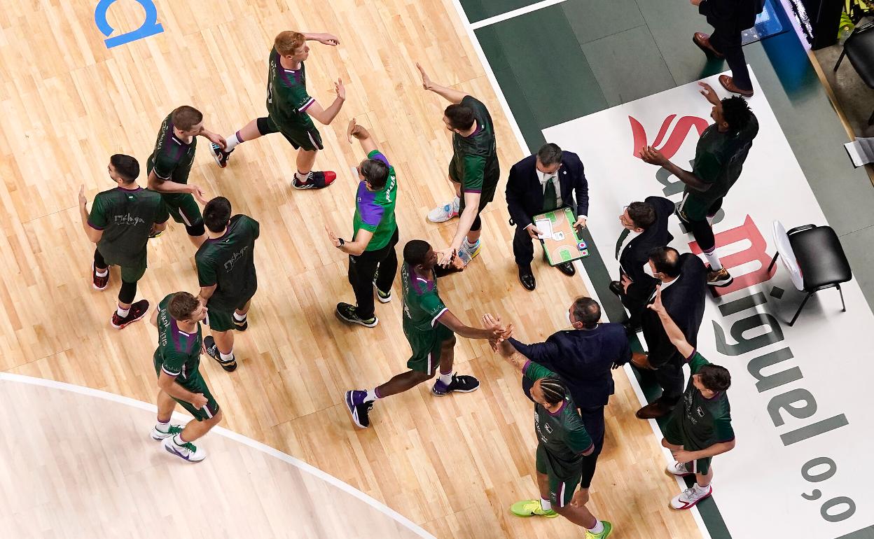 Los jugadores del Unicaja, durante un tiempo muerto en el Carpena. 