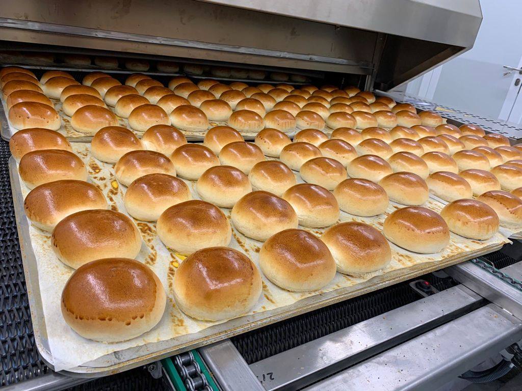 Imagen secundaria 1 - Salida a tiendas: En estos días, los bollos de Juanito Baker empiezan a venderse en los hipermercados de la cadena Carrefour. En aumento: Actualmente se producen 80.000 bollos a la semana. Carlos Pérez quiere crecer de forma gradual. Tres variedades: Pan de semillas (izquierda), pan clásico (delante) y el 'burger potato roll' americano, con almidón de patata para darle más elasticidad..