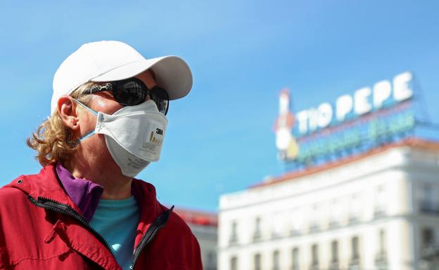 Un turista se cubre con una mascarilla en la Puerta del Sol de Madrid. 