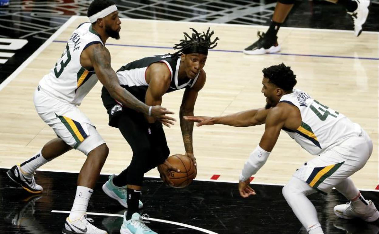 Terance Mann, héroe inesperado de la noche con 39 puntos, es defendido por Royce O'Neale y Donovan Mitchell.