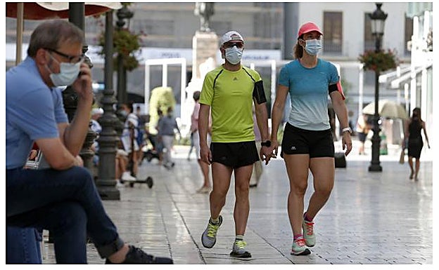 Personas portando mascarillas en la vía pública. 