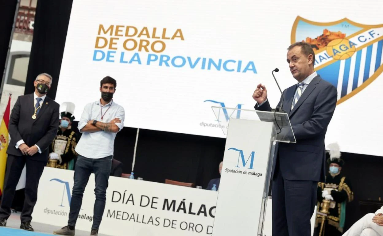 El administrador judicial del Málaga, José María Muñoz, agradece el premio 'Medalla de oro de la provincia' recibido por el club de Martiricos en un acto celebrado hace un mes junto al presidente de la Diputación, Francisco Salado, y el jugador malagueño Alberto Escassi.