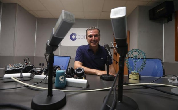 Arjona antes los micrófonos del estudio central de COPE Málaga posando junto al premio que le acredita como premio nacional de radio 2021.