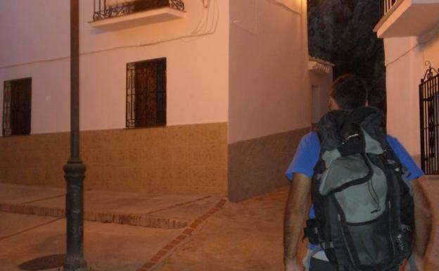 Un senderista comienza una ruta nocturna en las calles de Canillas de Aceituno