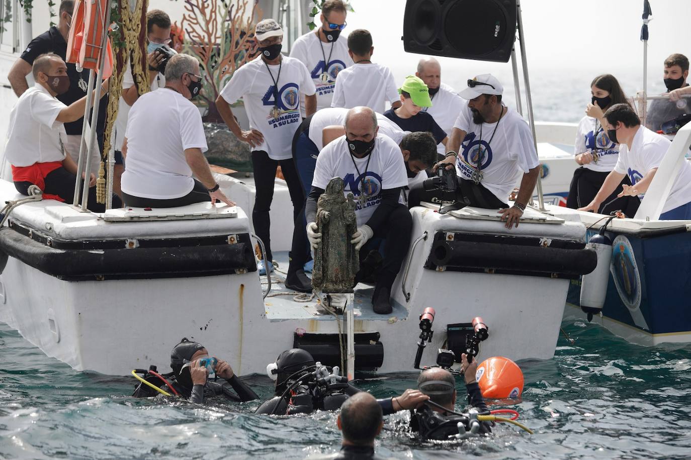El estandarte ha sido llevado hasta el Puerto de la capital, donde en la casa de botes del Club Mediterráneo ha embarcado para dirigirse hacia las playas de La Malagueta.