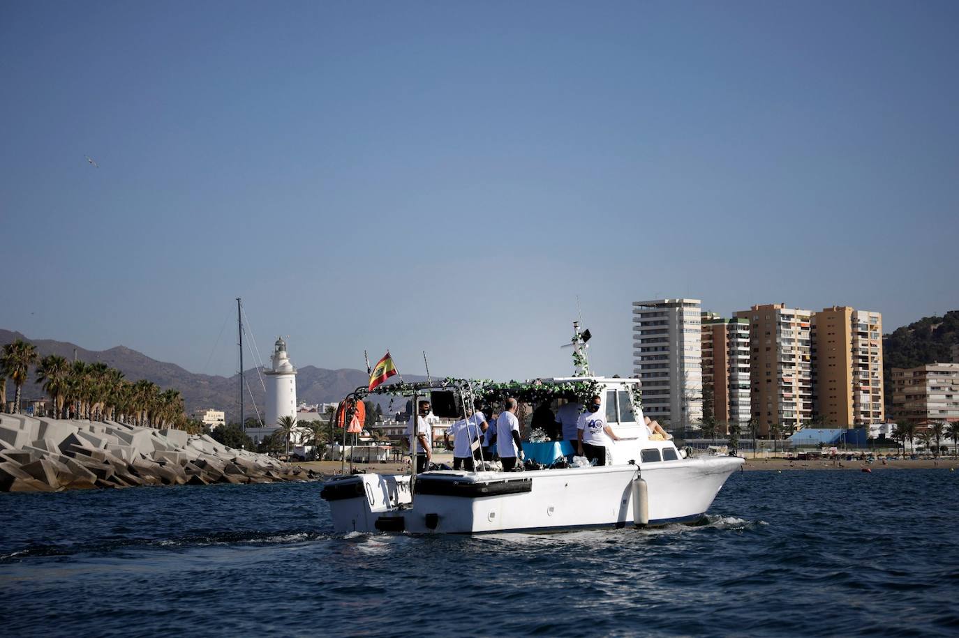 El estandarte ha sido llevado hasta el Puerto de la capital, donde en la casa de botes del Club Mediterráneo ha embarcado para dirigirse hacia las playas de La Malagueta.