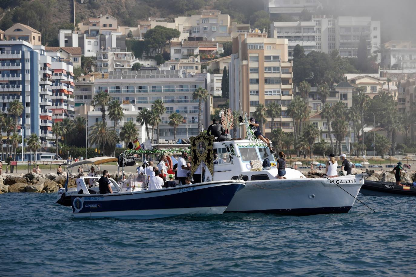 El estandarte ha sido llevado hasta el Puerto de la capital, donde en la casa de botes del Club Mediterráneo ha embarcado para dirigirse hacia las playas de La Malagueta.