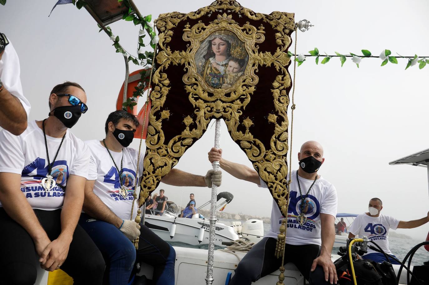 El estandarte ha sido llevado hasta el Puerto de la capital, donde en la casa de botes del Club Mediterráneo ha embarcado para dirigirse hacia las playas de La Malagueta.