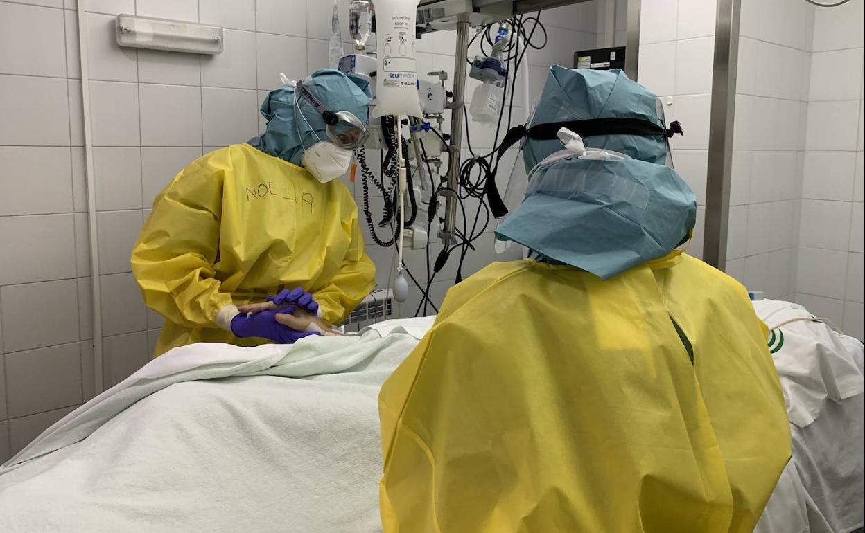 Dos sanitarios, con un paciente. 