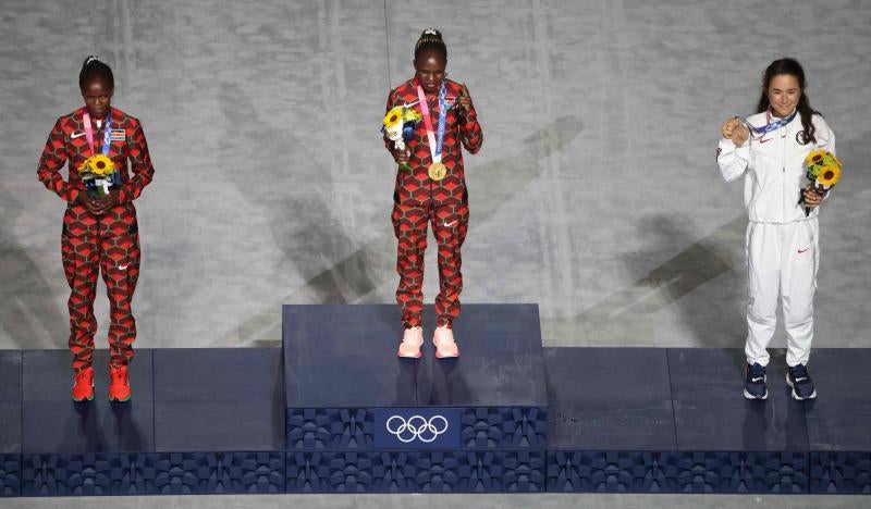 Salen los seis galardonados en categorías femenina y masculina de maratón para recibir las medallas sobre el cajón.