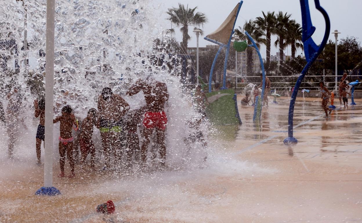 Jóvenes se refrescan en los juegos de agua de la playa de la Misericordia. 