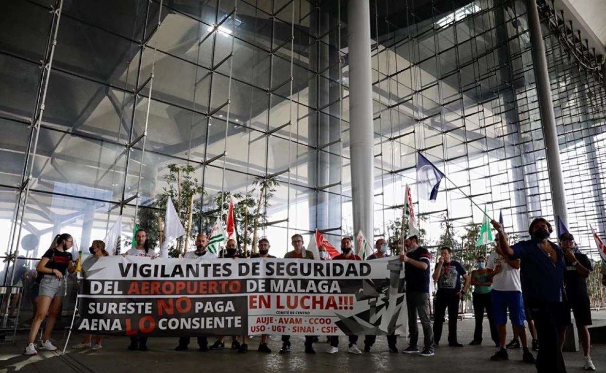 Vigilantes de seguridad del aeropuerto de Málaga se concentran en la entrada de la terminal de salidas. 