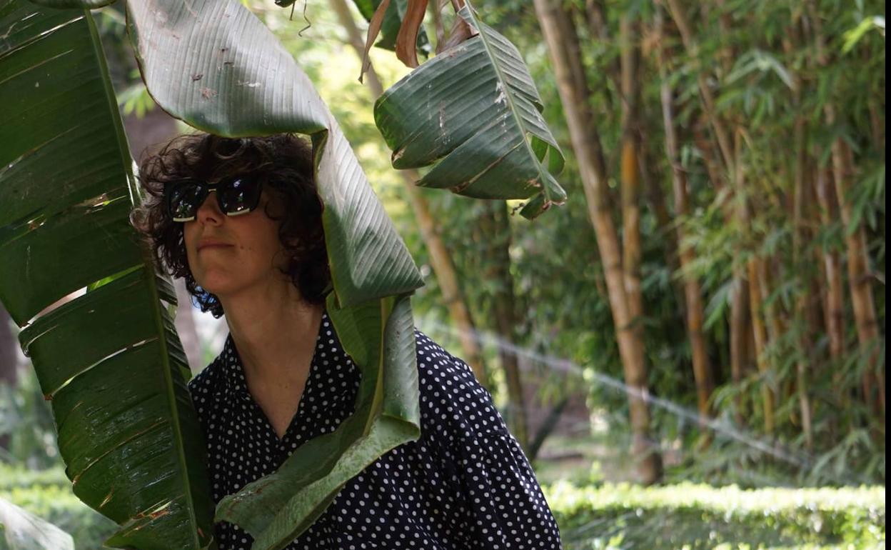 Violeta Niebla posa en los Jardines de Puerta Oscura entre hojas. 