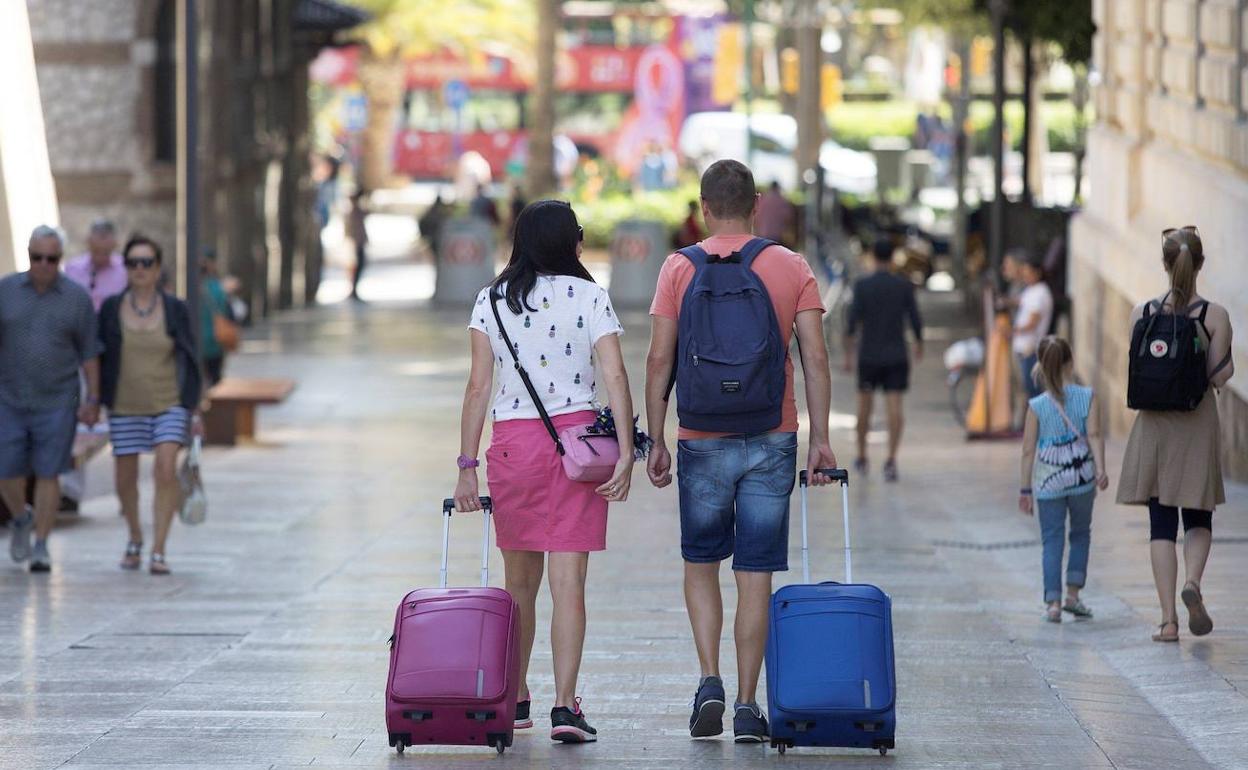 Turistas se desplazan por el Centro de la ciudad en busca de su alojamiento. 