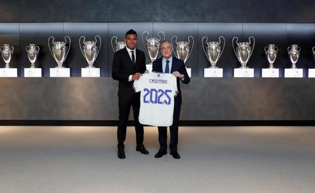 Casemiro posa junto a Florentino Pérez y una camiseta conmemorativa de su renovación. 