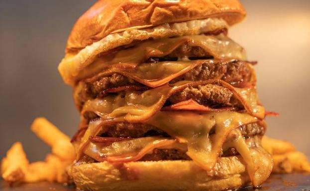 Imagen principal - Hay más de veinte hamburguesas distintas para elegir. El rincón de la fama en el establecimiento de Málaga. Los camareros son parte fundamental de este proyecto