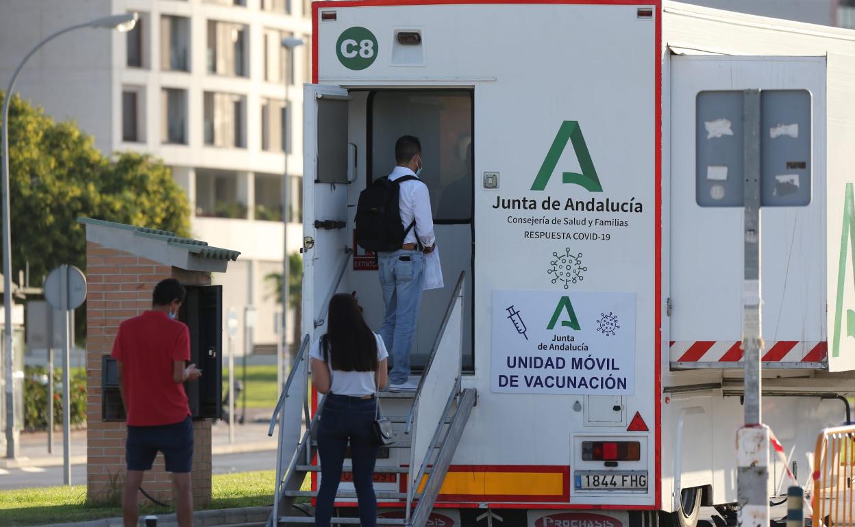 Estudiantes hacen cola en la unidad móvil de vacunación que estará miércoles y jueves en el aparcamiento de Teatinos. 