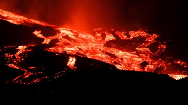 Flujos de lava y humo se elevan tras la erupción del volcán en la isla canaria de La Palma.