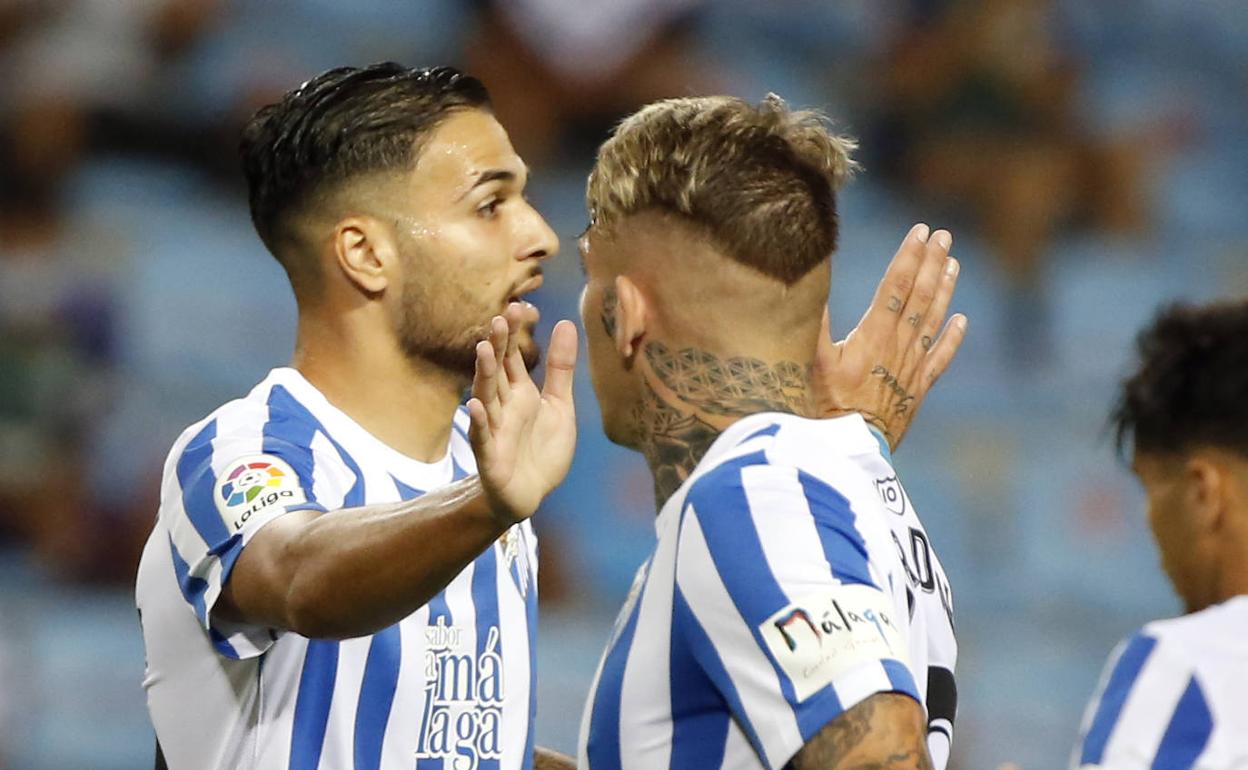 El jugador del Málaga, Antoñín Cortés, se saluda con su compañero Brandon durante un partido de Liga.