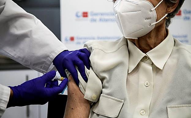 Una mujer recibe la tercera dosis de la vacuna contra el covid y la vacuna de la gripe en Madrid.