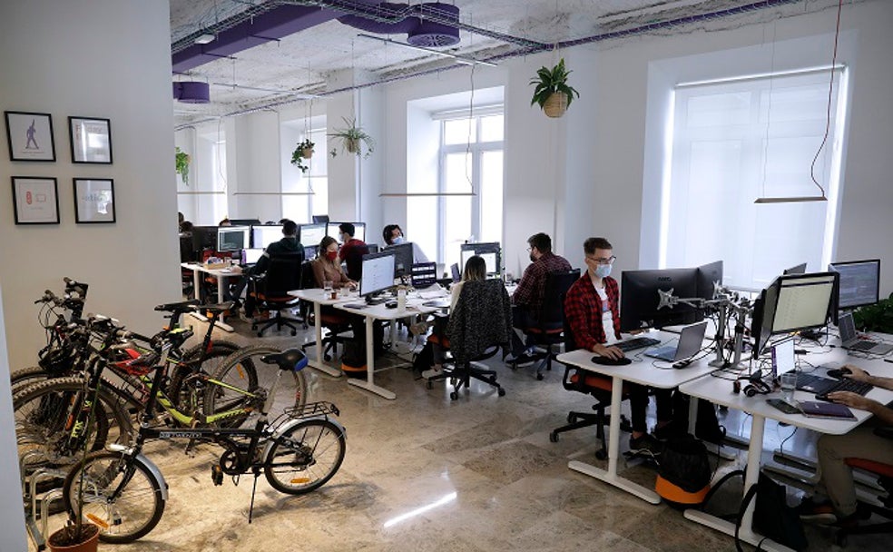 Trabajadores de Plytix en una parte de la oficina en la que se ubican los ordenadores y el espacio para colocar las bicicletas y los patinetes. 