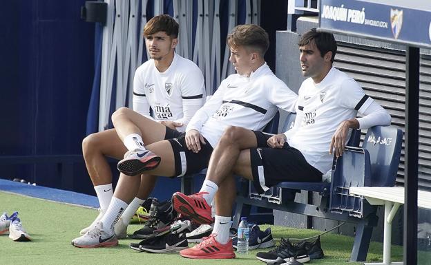 Los juagdores del Málaga, Kevin, Paulino y Escassi, observan el entrenamiento de sus compañeros desde fuera.