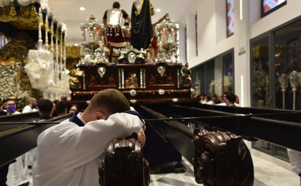 Un portador, sobre los varales del trono de Cristo de Azotes y Columna, en la casa hermandad. 