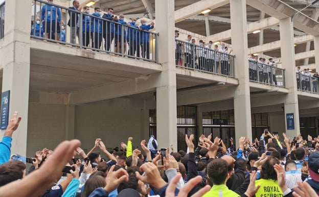 Los aficionados malaguistas animan a los jugadores y cuerpo técnico, situados en el interior del estadio, en alto, antes del partido. 